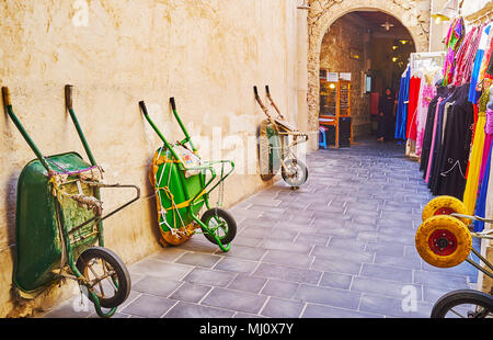 DOHA, Katar - Februar 13, 2018: den Grabhügeln der örtlichen Träger sind an der Wand in Souq Waqif lehnte, am 13. Februar in Doha Stockfoto