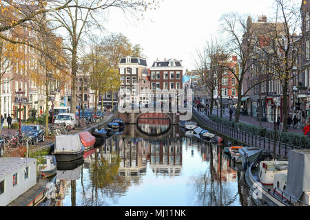 Holländische Architektur entlang der Grachten in Amsterdam im Herbst. Reflexionen im Wasser gesehen werden. Stockfoto