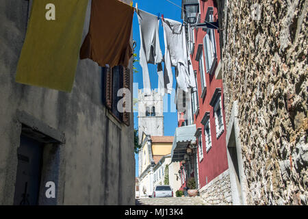 Istrien, Kroatien - Glockenturm aus einer typischen Gasse mit Kleidung trocknen auf Waschanlagen in der antiken Stadt Motovun gesehen Stockfoto