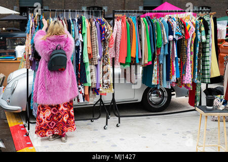 Alte Vintage Kleidung der Frauen zum Verkauf auf einem Rack zu einem retro vintage car boot Sale. Getreidespeicher Square, Kings Cross, London Stockfoto