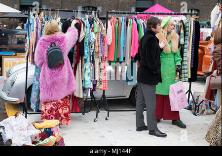 Alte Vintage Kleidung der Frauen zum Verkauf auf einem Rack zu einem retro vintage car boot Sale. Getreidespeicher Square, Kings Cross, London Stockfoto