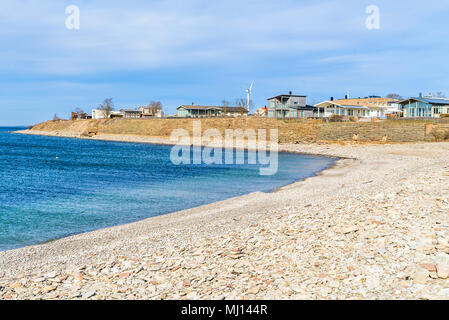 Teil des kleinen Küstenort Sandvik auf der Insel Oland, Schweden. Kalkstein, Kies der Strand in der Bucht und einige Häuser sind auf der Uhr gesehen Stockfoto