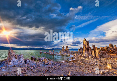 Tuffstein Türme, die unter Wasser gebildet wurden, am Ufer des Mono Lake, Kalifornien ergab, bei Sonnenuntergang, unter einem dramatischen Himmel. Stockfoto