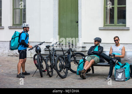 Fahrradkuriere- Arbeiten für Deliveroo, Britische online Food Delivery Unternehmen - eine Pause im Stadtzentrum Stockfoto