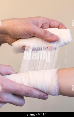 Der Kinderarzt Arzt bandagieren Kind arm. Der Arzt verbogen die Hand des Kindes. Close-up. Stockfoto