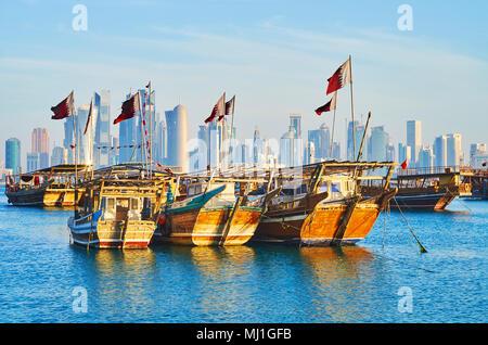 Der Kontrast von alten hölzernen Dhaus, im Hafen und die modernen Wolkenkratzer von Al Dafna Viertel auf dem Hintergrund, Doha, Qatar günstig. Stockfoto
