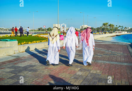 Araber, in der traditionellen Kleidung - ghuthrain (Kopftuch) und dishdasha oder thobe (Bademantel) Spaziergang entlang der Corniche, Doha, Qatar. Stockfoto