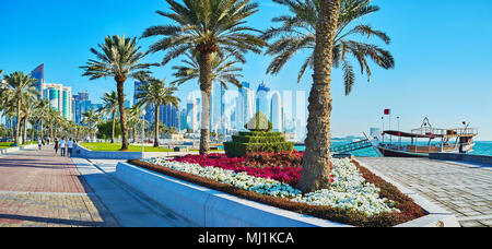 DOHA, Katar - Februar 13, 2018: Panorama der Park am Meer mit getrimmt Sträucher, üppigen Palmen und bunten Blumenbeeten auf Corniche in Al Stockfoto