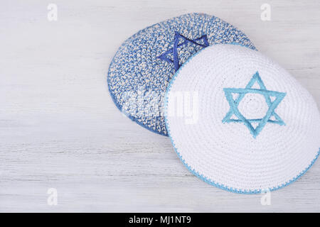 Gestrickte Kippa mit Bestickten blauen Stern Davids mit Kopie Speicherplatz auf einem Holztisch. Jüdische lifestyle Konzept Stockfoto