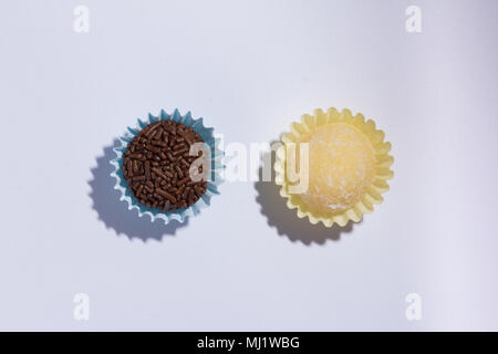 Handgemachte brasilianische Spezialitäten: Beijinho und Brigadeiro. In den Kindergeburtstag. Flach Design der Süßigkeit, die Kugel. Makro Nahaufnahme. Stockfoto