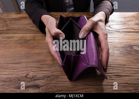 Nahaufnahme einer Hand, die leer ist ein Geschäftsmann, der Geldbeutel über Holz- Schreibtisch Stockfoto