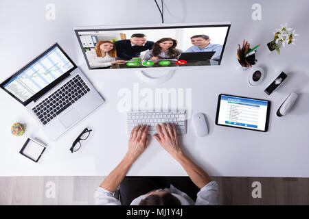 Unternehmer Videokonferenzen auf Computer mit Laptop und einer Tablette auf Schreibtisch Stockfoto