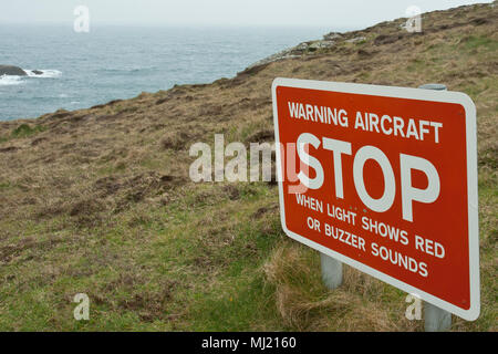 Auf einer Klippe mit Blick auf das Meer ist ein rotes Warnschild "ACHTUNG Flugzeug STOP "Spaziergänger auf dem Fußweg zu warnen, dass Flugzeuge, die ihren Weg kreuzen. Stockfoto