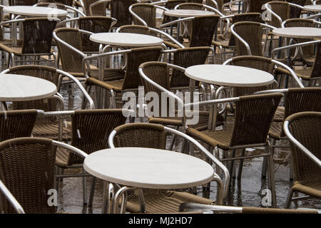 Leere nass Tische und Stühle in einem Cafe in St. Markusplatz, Venedig Stockfoto