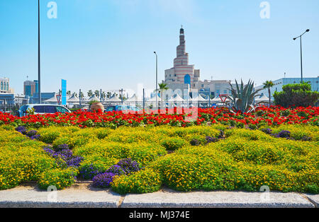 Die malerische Blumenbeete im Corniche mit Spirale Moschee, auch bekannt als Al Fanar, auf dem Hintergrund, Doha, Katar. Stockfoto