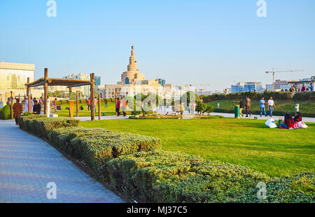 DOHA, Katar - 13. FEBRUAR 2018: Die überfüllten Souq Waqif Park, Familien genießen das Picknick auf der Wiese, Menschen auf Gassen zwischen den Grünen entfernt, an Feb. Stockfoto