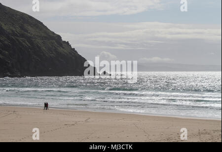 Zwei Leute auf einem Sandstrand in Irland - Coumeenoole Strand, Halbinsel Dingle in der Grafschaft Kerry, Irland Stockfoto