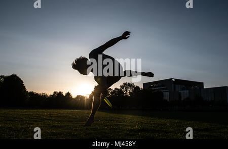 03. Mai 2018, Deutschland, Berlin: Benno Der Berlin-Jammers Fänge ein Frisbee vor dem Reichstag während des Sonnenuntergangs. Foto: Paul Zinken/dpa Stockfoto