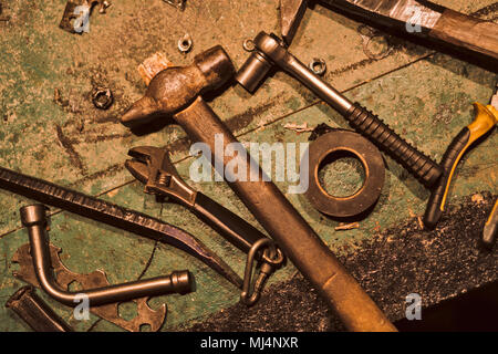 Noch immer leben von alter Hand tools. Auf der schmutzigen Tisch liegen ein Hammer, Isolierband, Schraubenschlüssel, Zangen, Mutter und andere Tools. Stockfoto