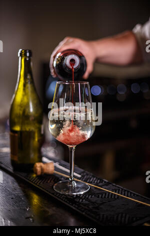 Barkeeper bereitet einen alkoholfreien Cocktail auf Champagner mit Erdbeer Sirup auf Basis Stockfoto