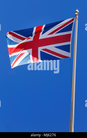Flagge Großbritannien fliegt vor einem blauen Himmel. Stockfoto