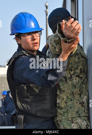 YOKOSUKA, Japan (April 4, 2018) - Mass Communication Specialist Seaman Angeles A. Miron von Los Angeles sucht ein Eindringling als Teil eines simulierten Einlasskontrolle Verletzung auf die USS Blue Ridge (LCC 19). Blue Ridge und ihre Crew haben jetzt eine abschließende Pflege und Training Phase in der Vorbereitung voll für den Einsatz in der Mission werden eingegeben. (U.S. Marine Bild Sammlung feiert die Tapferkeit Engagement Engagement und Opferbereitschaft der US-Streitkräfte und zivile Mitarbeiter. Stockfoto