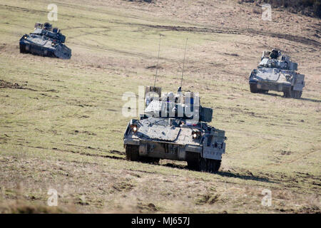 Eine Gruppe von M2 Bradley Kampffahrzeugen Bewegen einen Bereich während eines Robotic komplexe Verletzung Konzept Demonstration bei Grafenwöhr Training Area, Germany, April 6, 2018 zu sichern. Die robotische Komplexe Verletzung Konzept Mitarbeiter die Verwendung von Roboter und autonome Systeme (RAS) für Intelligenz, Unterdrückung, Schleier, und Missionen. (U.S. Armee Bild Sammlung feiert die Tapferkeit Engagement Engagement und Opferbereitschaft der US-Streitkräfte und zivile Mitarbeiter. Stockfoto