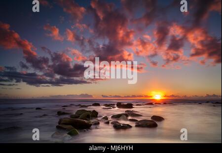 Sonnenaufgang über der Ostküste von Sydney, wenn die Wolken über in freier Form Mode getanzt Stockfoto