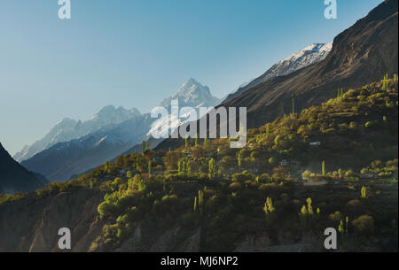 Landschaft Landschaft, Schnee berg und ländlichen Dorf mit Wald auf einer Klippe bei Hunza Tal in Pakistan Stockfoto