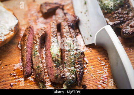 In Scheiben geschnitten Angus Steak mit Kräuterbutter, auf Brötchen serviert mit Meerrettichsauce Stockfoto