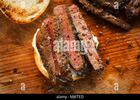 In Scheiben geschnitten Angus Steak mit Kräuterbutter, auf Brötchen serviert mit Meerrettichsauce Stockfoto