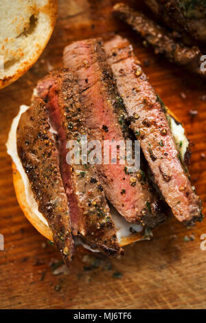 In Scheiben geschnitten Angus Steak mit Kräuterbutter, auf Brötchen serviert mit Meerrettichsauce Stockfoto