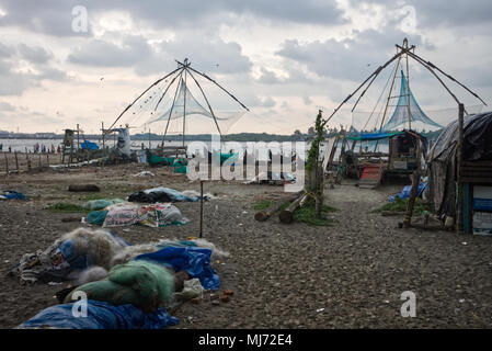 Kochi (Cochin) Kerala/Indien - 15. April 2018: Fischernetze liegen leere auf einem Strand in Cochin (Kochi) neben chinesischen Fischernetze (Cheena vala) o Stockfoto