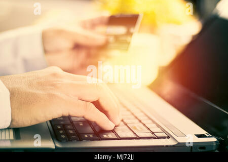 Geschäftsmann mit der Eingabe auf der Tastatur und halten der Karte im Coffee Shop Stockfoto