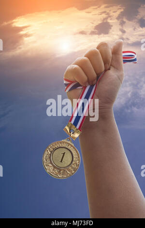 Hand zeigen Golden Award, Nummer 1, Medaille auf Himmel Hintergrund, Konzept in Sieger und Meister Stockfoto