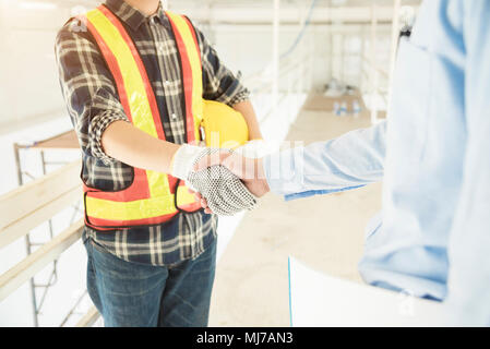Erfolg behandeln in den Bau und die Innenausstattung. Unternehmer und Ingenieur handshaking am Standort. Bild zum Text Nachricht hinzufügen. Hintergrund für Design art wor Stockfoto
