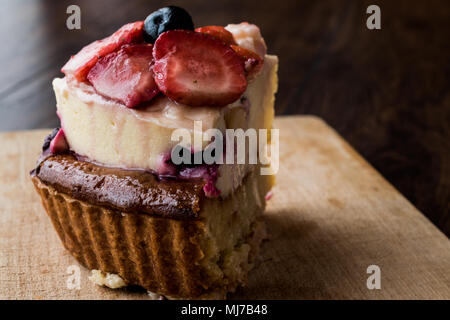 Obstkuchen Slice mit Erdbeere und Beeren auf Holz- Oberfläche. Stockfoto