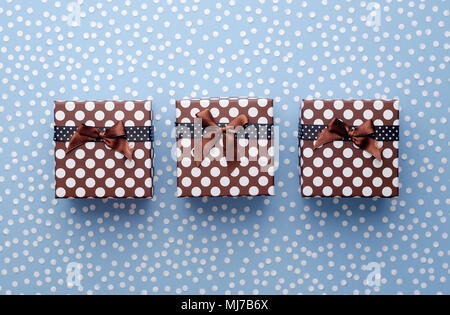 Weihnachten Geschenk Boxen mit Schnee Konfetti in einer Reihe über blauen Hintergrund, oben anzeigen Stockfoto