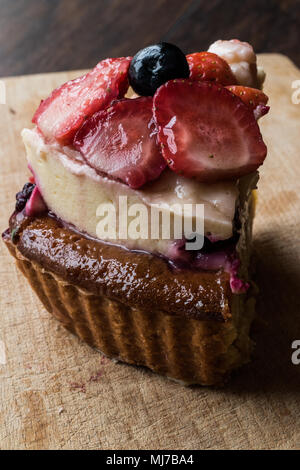 Obstkuchen Slice mit Erdbeere und Beeren auf Holz- Oberfläche. Stockfoto