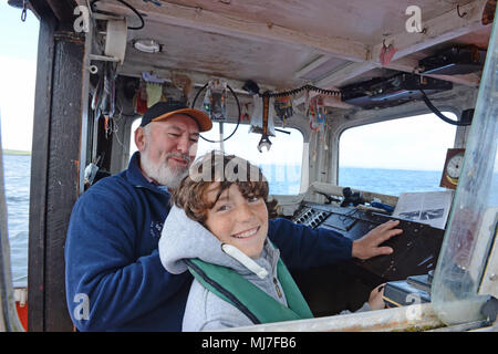 Junge fischen mit seinem Opa in einem Meer boot Makrelenfangs der Küste der Shetlandinseln Stockfoto