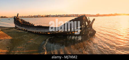 Der Panoramablick auf die Wracks der alten hölzernen Segelboot zerstört und verbrannt auf der Bank der Seixal Bucht des Tejo im Licht der untergehenden Sonne. Lis Stockfoto