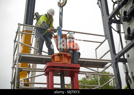 MOANA, NEUSEELAND, November 4, 2017: Ingenieure arbeiten im Regen einrichten Hebezeug das Gehäuse aus Stahl ein Öl gut, das Bein zu entfernen. Stockfoto