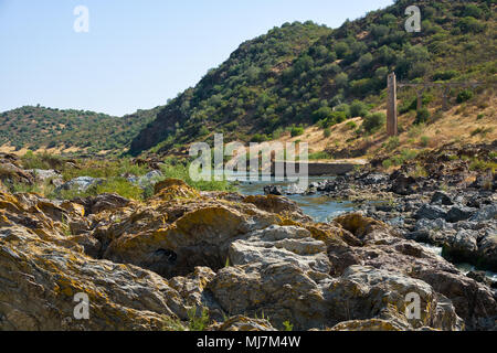 Fluss Guadiana vor dem Pulo do Lobo (Wolf's Leap) Wasserfall und die Reste der alten römischen Aquädukt. Guadiana River Valley Natural Park, Alentej Stockfoto