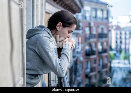 Junge Latein. traurig und deprimiert Frau, die auf einem Balkon Gefühl überwältigt und Leiden Depressionen in der psychischen Gesundheit Konzept Stockfoto