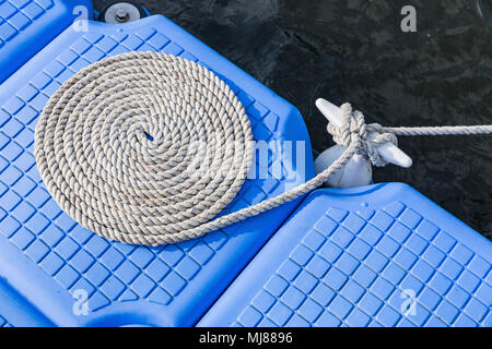 Seil auf Kunststoff Ponton schwimmend im Meer, Kunststoff Schwimmdock, Seil gebunden in einen Kreis Stockfoto