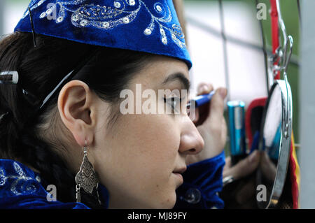 Krimtatarischen Tänzerin im nativen Kleid vorbereiten für Konzert, Verkleiden und Schminken. Das Feiern von Hidirellez. April 23,2018. Kiew, Ukraine Stockfoto