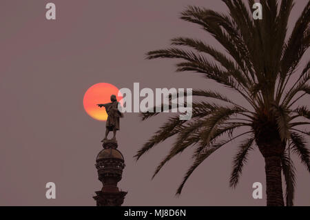 Palm Tree und die Statue von männliche Figur auf Sockel mit Vollmond hinter, Dämmerung. Stockfoto