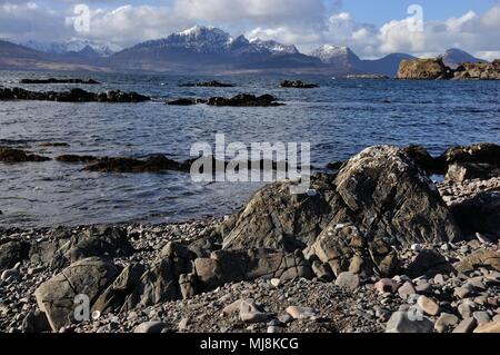 Verschneite Bla bheinn, Black Cuillin vom felsigen Ufer am Tokavaig auf der Halbinsel Sleat, Isle of Skye Stockfoto