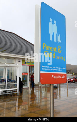 Eltern und Kind Parkplatz Schilder in einem Tesco Parkplatz an einem regnerischen Tag Stockfoto