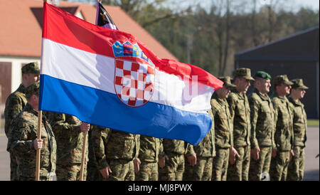 Kroatische Soldaten stehen an Aufmerksamkeit während der Übertragung der Autorität Zeremonie, wo Sturm Batterie übernimmt für Volcano Batterie als Teil des Battle Group Polen auf der Bemowo Piskie, Polen, 19. April 2018. Diese Soldaten sind ein Teil der einzigartigen, multinationalen Battle Group aus USA, Großbritannien, Kroatischen und rumänischen Soldaten, die mit der polnischen 15 mechanisierte Brigade als Abschreckung Kraft im Nordosten Polens zur Unterstützung des NATO-Enhanced vorwärts Präsenz dienen. (U.S. Armee Foto von SPC. Andrew McNeil/22 Mobile Public Affairs Abteilung) Stockfoto